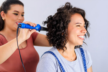 Latina salon client is happy while observing the results of her hair treatment