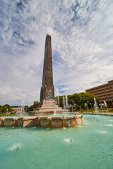 Obraz na płótnie Canvas Grand Obelisk Monument with Fountain in Urban Park, Low Angle View