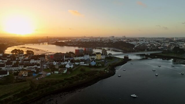 Sunset over Lorient's river and colorful houses.
