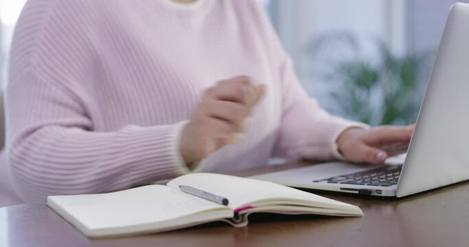 Woman, laptop and hands writing for research, schedule or planning reminder in diary at office. Closeup of female person or employee taking notes in book with computer for idea or agenda at workplace