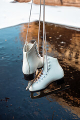 Figure skates above a frozen ice surface outside. Ice skating on the natural ice. Frozen lake and figure skates in The Netherlands. 