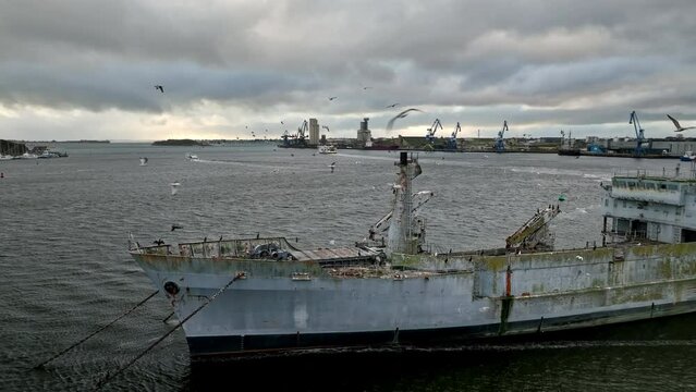 Rusting shipwreck foregrounds Lorient's active port.