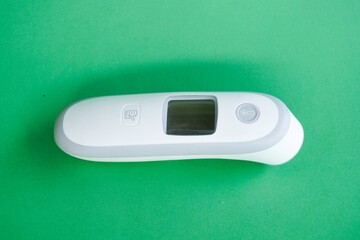 Medical officers or health workers wear blue medical gloves and hold a thermogun. isolated on green