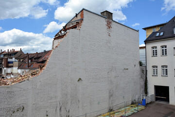 The construction site with the dismantling of the walls of the building on the street of the city....