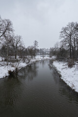 Zimowa panorama rzeki Osobłogi w popołudniowych godzinach pochmurnego szarego dnia w Zachodniej Polsce - obrazy, fototapety, plakaty