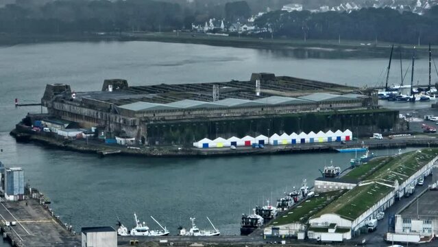 Historic Lorient submarine base looms over harbor.