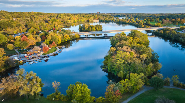 Aerial Autumn Glow Over Kayak-Lined Park and Bridge, Gallup Park, Michigan - Powered by Adobe