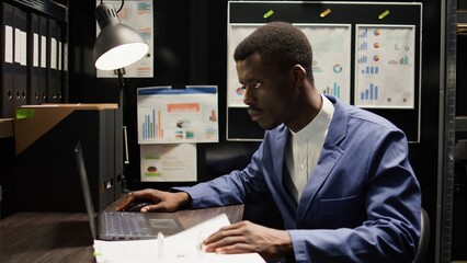 Naklejka premium Detective inspector works in office, analyzing forensic evidence and conducts detailed background checks. Police officer identifying illegal activity, and gathering crucial information. Zoom-in shot.