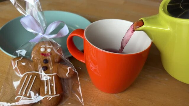 bright dishes pour red tea Hibiscus near the gingerbread man gift Christmas. delicious
