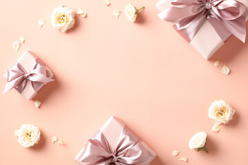 Valentine's Day card design. Flat lay gift boxes with pink ribbon bow, rose buds on peach fuzz...