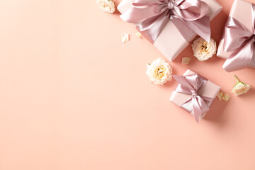 Valentine's Day gifts with pink ribbon bow, rose buds on peach fuzz background. Love, romance concept. Flat lay, top view, copy space