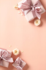 Gift boxes with pink ribbon bow and rose buds on peach fuzz background. Happy Valentines day, love,...