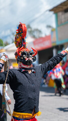 People with devil masks dancing at the Diablada Pillarena, a traditional festival of Ecuador