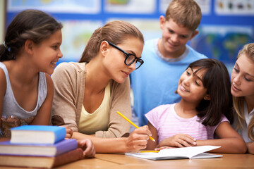 Teacher, students and writing for learning, education or tutoring in classroom at school. Woman,...