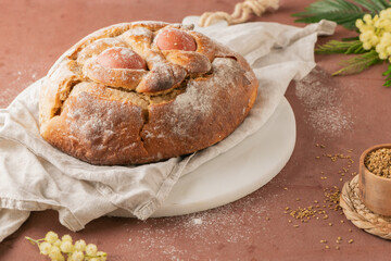 Portuguese traditional Easter cake with eggs. Typical Folar de Vale de Ilhavo, Aveiro, Portugal. Blossom flowers and colorful painted eggs decorated with feathers on easter table