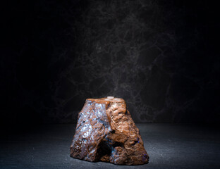 stones and ice for the podium. natural brown stones in a thin layer of ice on a dark background for the presentation of a product of cosmetics, medicine, perfumery, jewelry