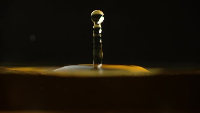 Cosmetics golden serum liquid. Falling drop macro abstract background. Cosmetic moisturizer essence gel. Collagen fluid bubble molecule. Yellow moisturizing cream oil. Beauty skin health care concept