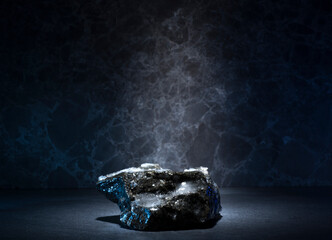 stones and ice for the podium. natural black stones in a thin layer of ice on a dark background for...