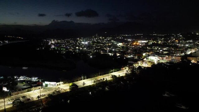Imagem a&eacute;rea de drone da cidade de Guarapari a noite, praia do morro e prainha de muqui&ccedil;aba iluminadas. Decora&ccedil;&atilde;o de natal e festas de final de ano.