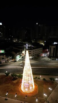 Imagem aérea de drone da cidade de Guarapari a noite, praia do morro e prainha de muquiçaba iluminadas. Decoração de natal e festas de final de ano.