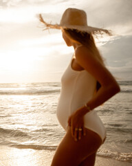 Happy pregnant woman with  on beach look at sunset . Cheerful expectant mother standing on beach....