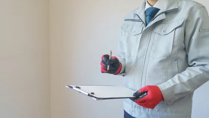 Foto op Plexiglas マンションの壁紙を点検する作業服の男性｜リフォーム調査・見積り　イメージ © aomas
