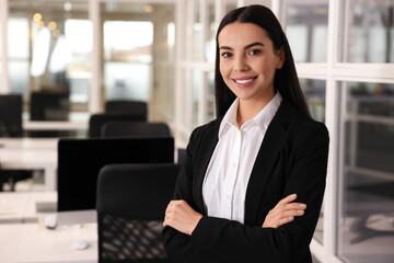 Happy woman with crossed arms in office, space for text. Lawyer, businesswoman, accountant or manager