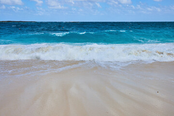 Fototapeta na wymiar Serene Tropical Beach with Turquoise Ocean and White Waves