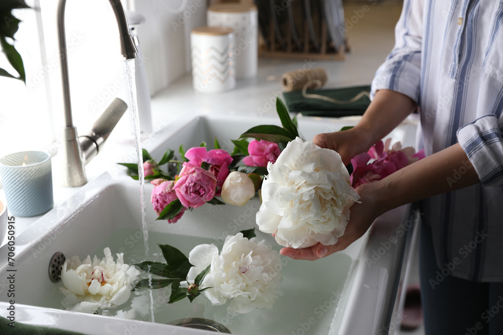 Canvas Prints Woman with beautiful peonies near kitchen sink, closeup