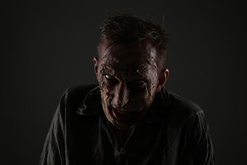 Scary zombie on dark background. Halloween monster