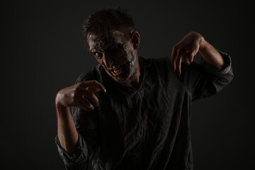 Scary zombie on dark background. Halloween monster