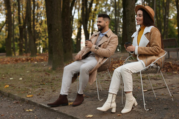Fototapeta na wymiar Romantic young couple spending time together in autumn park, space for text