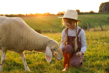 Girl with sheep on pasture. Farm animal