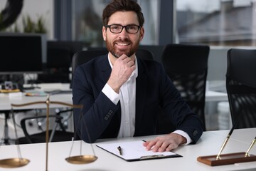 Portrait of smiling lawyer at table in office