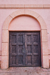 Fototapeta na wymiar Weathered Wooden Doors in Peach Wall, Nassau