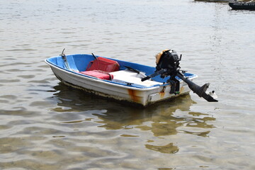 empty row boat with motor in water