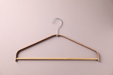 One wooden hanger on beige background, top view