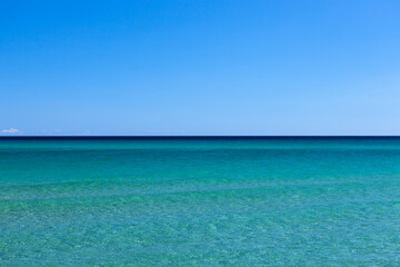 Clear turquoise water of Mediterranean sea with blue sky at Sardinia, Italy on sunny day. Amazing sea view.