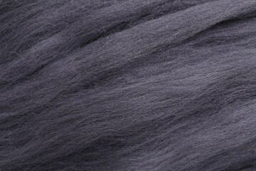 Grey felting wool as background, closeup view