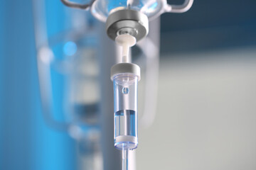 IV drip chamber against blurred light background