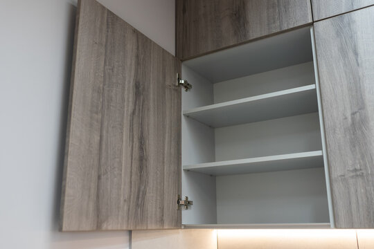 Open kitchen cabinet door. Modern classic kitchen interior with furniture and appliances
