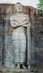 Fototapeta na wymiar Ancient Rock Buddha Statue Amidst Sri Lanka's Historic Temples
