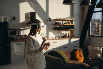 In the comfort of her apartment, a stunning young lady plays an online game with a VR headset.