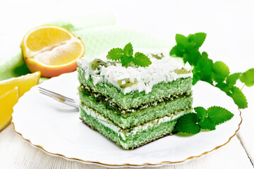 Cake with orange and mint in plate on table