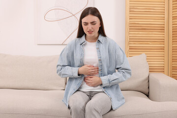 Young woman suffering from stomach pain at home