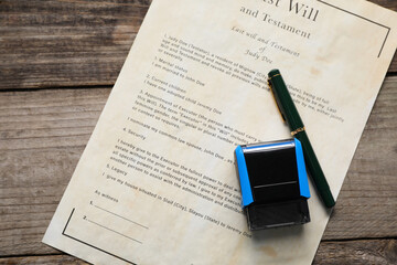 Last Will and Testament with fountain pen and stamp on wooden table, top view