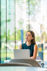 Portrait of an Asian Business Woman Working on a Laptop with a Elegant Look and Smile Outside the Office
