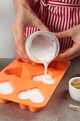 Woman making natural handmade soap at grey stone table, closeup