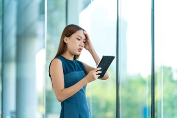 Young Asian Woman Holding Digital Tablet Feels Stressful and Upset