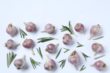 Fresh garlic and rosemary on white background, flat lay. Space for text
